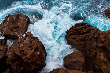 Waves crashing on rocks. The blue sea breaking against the rocks