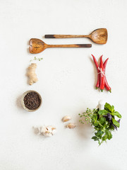 Frame of various spices, seasonings and fresh herbs on a light background. Top view. copy space