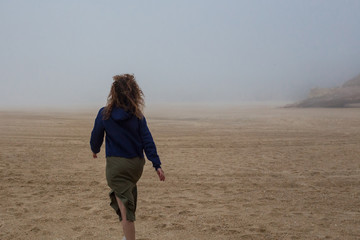 Sea and sandy beach in dense fog, autumn day