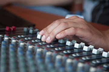 Hand adjusting audio mixer