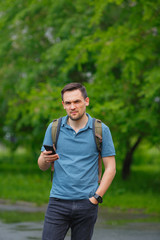 young man using mobile phone in the forest while hiking