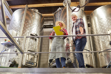 Winzer Team mit Checkliste am Gärtank