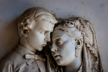 Primo piano della statua di una madre con il suo bambino su una tomba del cimitero monumentale di...