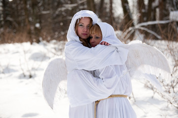 Obraz premium girls with white hoodies with angel wings on a winter background