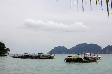 Boats in the middle of the sea and mountain bottoms on the Phi Phi islands of Thailand