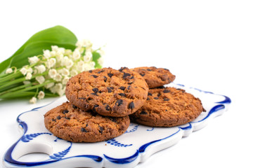 cookies with chocolate crumbs on the background of a bouquet of lilies, white background