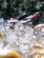 Ice cubes in ice bucket over alcoholic and non alcoholic cold drinks, summer terrace concept