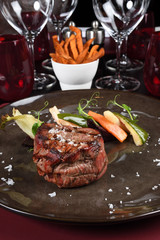 Rib eye steak, seasonal vegetables and sweet potatoes Fries in the background. Fine dining gourmet
