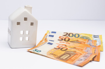 White house with euro cash money as a concept of investment in property. Benefit f a broker after selling house.