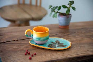 colorful handmade ceramic coffee cups on wooden table 