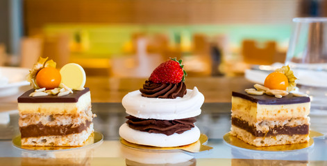 Meringue cake with dark chocolate and strawberry on top, in arestaurant setting, blurred background