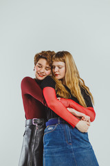 Two beautiful girls lesbians hugging on a white background