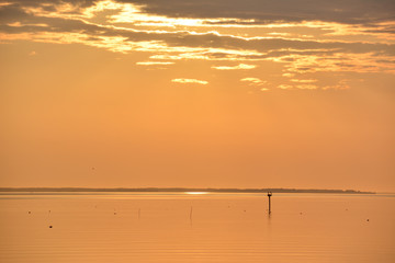 Sunrise over the Chesapeake Bay with crab pot buoys floating on the calm water surface