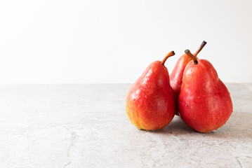 Three red pears on a light background