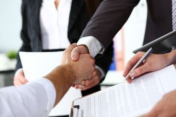 Man in suit and tie give hand as hello in office closeup