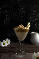 Dalgona coffee - instant coffee or espresso, whipped with sugar and hot water, a trend drink with coffee foam and milk sprinkled with powdered sugar