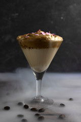 Iced Dalgona Coffee in smoke, the Korean coffee drink on wooden background, Whipped trend drink with coffee foam and milk.