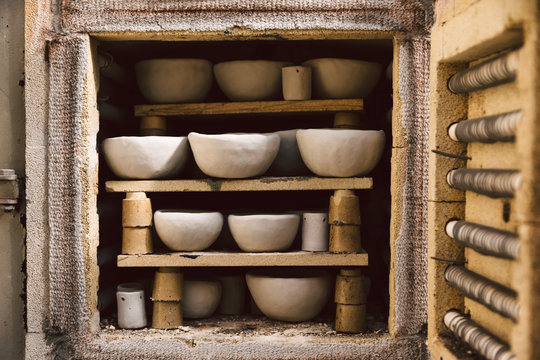 Viele rustikale Schalen aus Ton im Brennofen. Rohe Keramikprodukte ohne Glasur, Ansicht. Kunstgewerbe, Hobby und Lifestyle