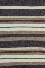 Texture for the background. Material from wool, striped from beige and dark shades.