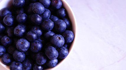blueberries in a bowl and on the table scattered in the form of a heart