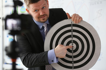 Male millennial vlogger hold target darst