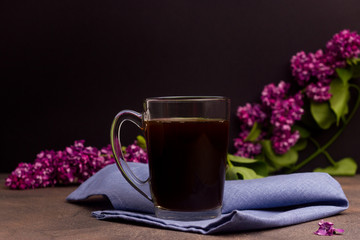 Cup with coffee on a table with flowers in the background