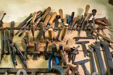 Old craftsman's tools lined up on the wall.