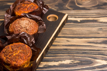 Homemade delicious muffins on wooden background close-up