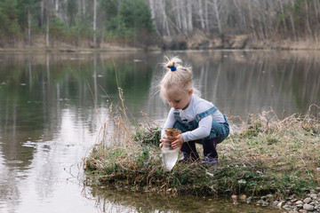 Little girl catches and feeds fish