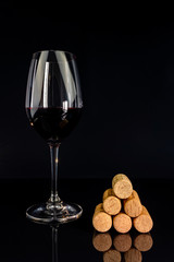 red wine in a glass on a high leg on a black background