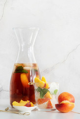 Iced cold peach tea with fruit slices and mint