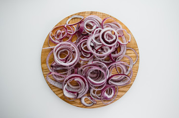 Red onion rings on a wooden board isolated on white background. Flat lay. Cooking concept 