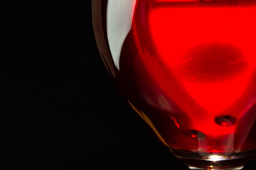 red wine in a glass on a high leg on a black background