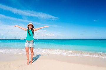 Fototapeta na wymiar Young beautiful woman having fun on tropical seashore. Happy girl background the blue sky and turquoise water in the sea on caribbean island