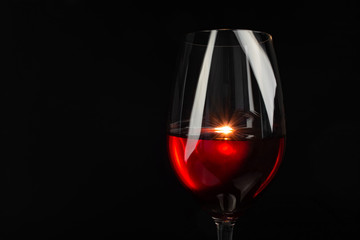 red wine in a glass on a high leg on a black background