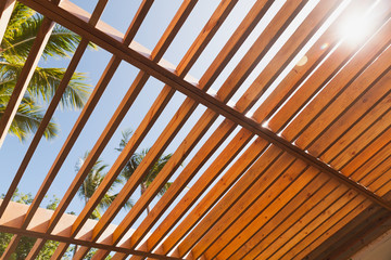 Wooden sunshade roof structure under blue sky