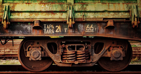 Close up fragment of old rusty train cargo wagon. Rusty wheels of an old rail car with weathered...