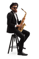 Naklejka premium Bearded musician holding a saxophone and sitting on a chair