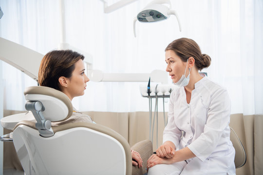 Female dentist discussing a report with her patient at the clini