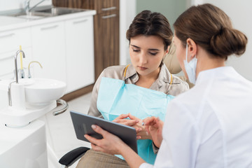 Obraz premium A doctor with her patient in the dentistry office, using a table