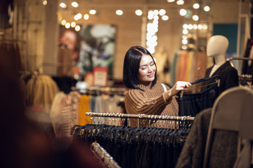 A woman shopping for clothes. Shopper looking at clothing indoor