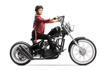 Fototapeta na wymiar Female biker with a helmet and a leather jacket riding a chopper motorbike