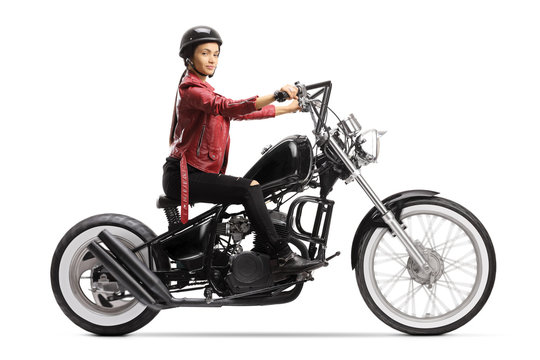 Female biker with a helmet and a leather jacket riding a chopper motorbike