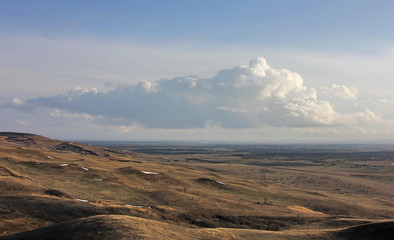 clouds over the mountains,  panorama, autumn landscape. A huge cloud over the endless steppe from a bird's eye view
