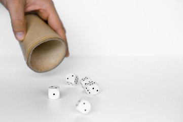 Rolling white dices with brown leather cup