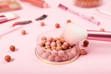 Ball blush and brush on a pink background. Close-up
