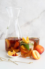 Iced cold peach tea with fruit slices and mint