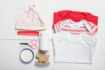 Flat lay composition with baby clothes and accessories on wooden background