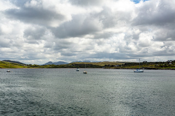 Sailing boats moored in the bay of Inishbofin Island, calm waters of the Atlantic Ocean, overcast...