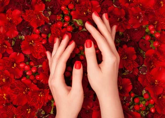 Foto op Canvas Female hands with bright red manicure on luxurious floral background. © Soleness Moon